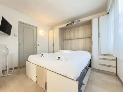 a bedroom with a large bed and a tv at Le Cozy by Winsome Destination in Cannes