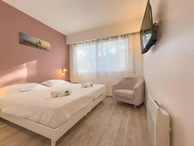 a bedroom with a bed and a tv and a window at Le Cozy by Winsome Destination in Cannes