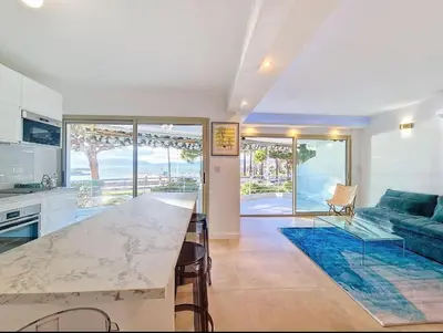 a kitchen and living room with a table and a couch at Le Romance - Palm Beach - Sea View - Wi-Fi - Air Conditioning in Cannes