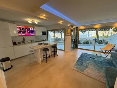 a kitchen and living room with a couch and a table at Le Romance - Palm Beach - Sea View - Wi-Fi - Air Conditioning in Cannes