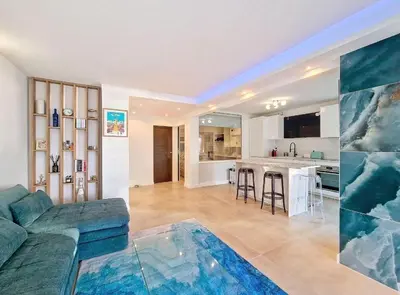 a living room with a couch and a kitchen at Le Romance - Palm Beach - Sea View - Wi-Fi - Air Conditioning in Cannes