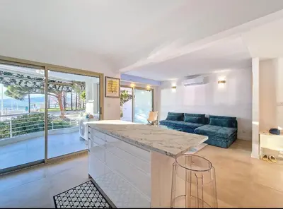 a kitchen and living room with a blue couch at Le Romance - Palm Beach - Sea View - Wi-Fi - Air Conditioning in Cannes
