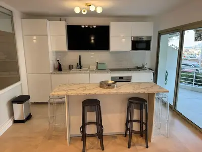 a kitchen with a island with two bar stools at Le Romance - Palm Beach - Sea View - Wi-Fi - Air Conditioning in Cannes