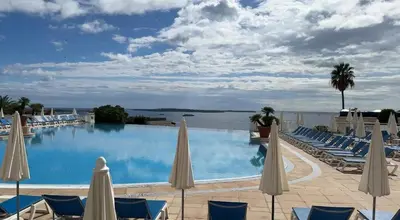 a large swimming pool with chairs and umbrellas at Vue mer imprenable, piscine à débordement - Cannes in Cannes
