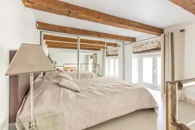 a metal spiral staircase in a white room with a wooden door at Heart of Cannes Luxury Stay - Steps from Beach & Palais in Cannes
