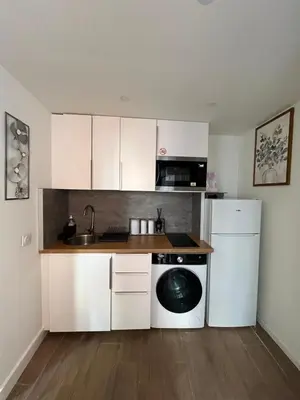 a kitchen with white cabinets and a dishwasher at Palais des festivals Studio meublé in Cannes