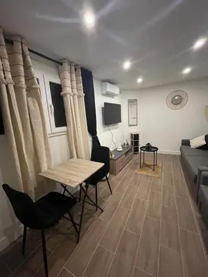 a living room with a table and chairs and a couch at Palais des festivals Studio meublé in Cannes