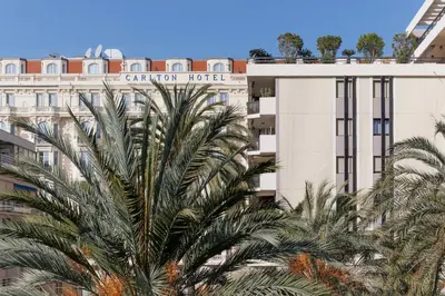 a building with palm trees in front of it at Immogroom Luxury 1 bedAppartment AC Terrace in Cannes
