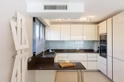 a kitchen with white cabinets and a black counter top at Immogroom Luxury 1 bedAppartment AC Terrace in Cannes