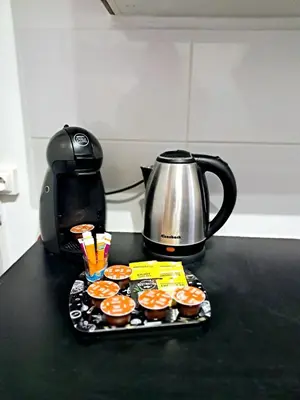 a tray of cupcakes and a tea kettle on a counter at 4 - Person Apartment with Sea View terrace in Cannes