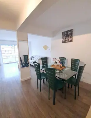 a dining room with a table and green chairs at 4 - Person Apartment with Sea View terrace in Cannes