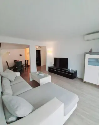 a living room with a white couch and a tv at 4 - Person Apartment with Sea View terrace in Cannes