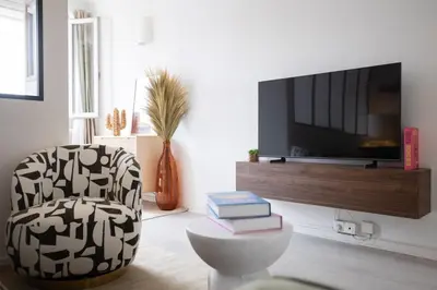 a living room with a chair and a tv at Appartement à Cannes in Cannes