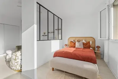 a bedroom with a bed with red sheets and pillows at Appartement à Cannes in Cannes
