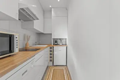 a kitchen with white cabinets and a microwave at Appartement à Cannes in Cannes