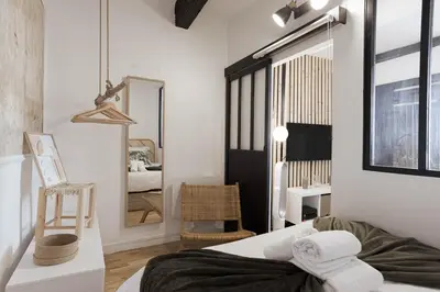 a bedroom with a bed and a mirror in it at Charme du Suquet - 12mn du Palais&Plage, cosy, neuf in Cannes