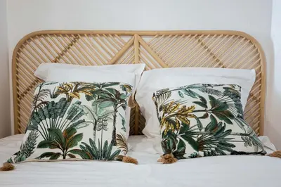 two pillows with palm trees on them on a bed at Charme du Suquet - 12mn du Palais&Plage, cosy, neuf in Cannes