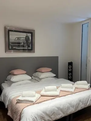 a large bed with four pillows and a picture on the wall at Verginia in Cannes