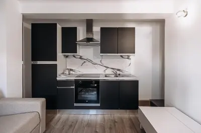 a kitchen with black cabinets and a stove top oven at Beautiful Studio in Cannes, near beach and Croisette in Cannes