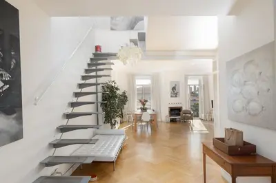 a white staircase in a living room with a table at Center of Cannes 100m2 bright apartment in Cannes