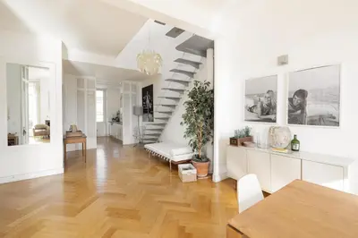 a living room with a wooden floor and white walls at Center of Cannes 100m2 bright apartment in Cannes