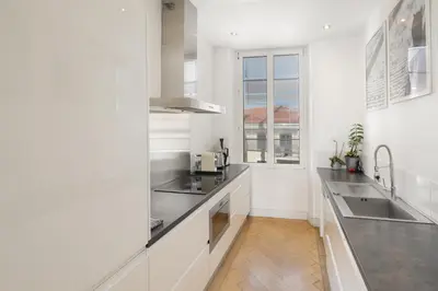a kitchen with white walls and stainless steel appliances at Center of Cannes 100m2 bright apartment in Cannes
