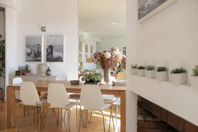 a dining room with a wooden table and white chairs at Center of Cannes 100m2 bright apartment in Cannes