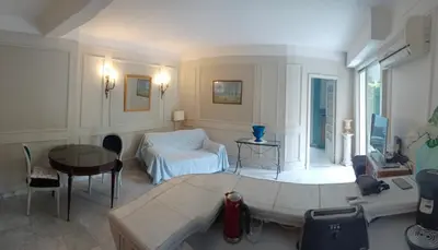 a busy city street with palm trees and the ocean at Appartement jardin in Cannes