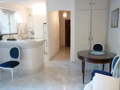 a living room with a bed and a table at Appartement jardin in Cannes