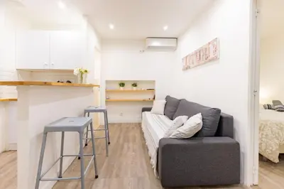 a living room with a couch and a kitchen at Sublime Appartement 5 Mins à Pied Du Palais Des Festivals by Halldis in Cannes