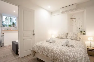 a living room with a couch and a kitchen at Sublime Appartement 5 Mins à Pied Du Palais Des Festivals by Halldis in Cannes