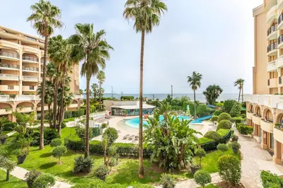 an aerial view of a resort with a pool and palm trees at Family Sea view with pools near shops and beaches in Cannes