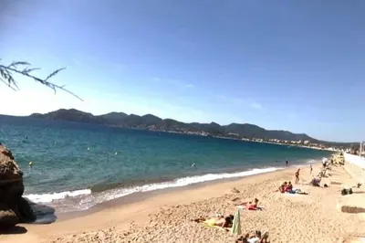 a group of people on a beach near the water at Family Sea view with pools near shops and beaches in Cannes