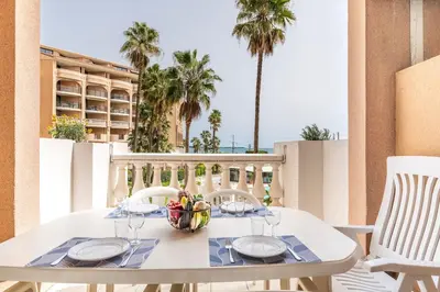 a white table with a bowl of fruit on a balcony at Family Sea view with pools near shops and beaches in Cannes