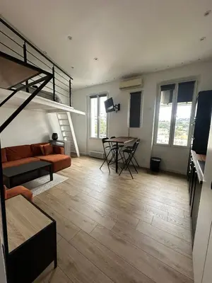 a living room with a loft bed and a table at Studio cosy, 8 min à pied du Palais et de la Plage in Cannes