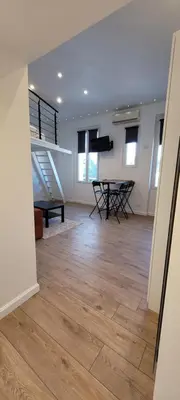 a living room with a staircase and a table at Studio cosy, 8 min à pied du Palais et de la Plage in Cannes