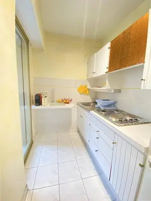 a kitchen with white cabinets and a stove at Cannes proche Croisette - Studio in Cannes