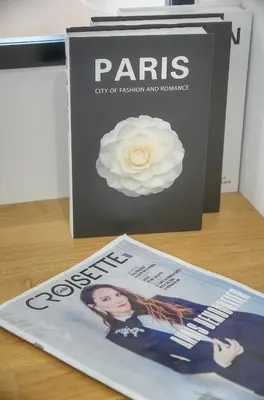 a magazine sitting on a table next to a book at Isa - Clim - WiFi - Balcon - VCA in Le Cannet