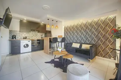 a living room with a couch and a kitchen at Isa - Clim - WiFi - Balcon - VCA in Le Cannet