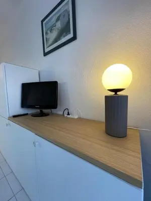 a desk with a television and a lamp on it at Appartement Cannes, Piscine - Terasse - 4 Personnes in Cannes