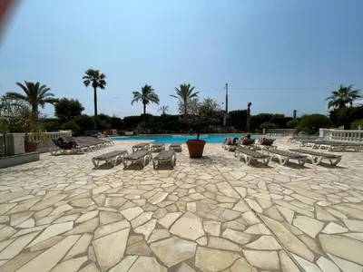 a pool with a bunch of tables and chairs at Appartement Cannes, Piscine - Terrasse, Jardin Privatif - 4 Personnes in Cannes