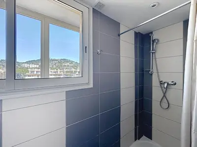 a bathroom with a shower and a window at Beachfront 2-bedroom apartment with balcony in Cannes