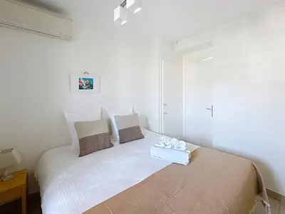 a white bedroom with a bed with a tray on it at Beachfront 2-bedroom apartment with balcony in Cannes