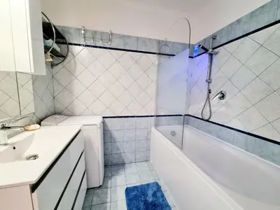 a white bathroom with a tub and a sink at Positive in Cannes