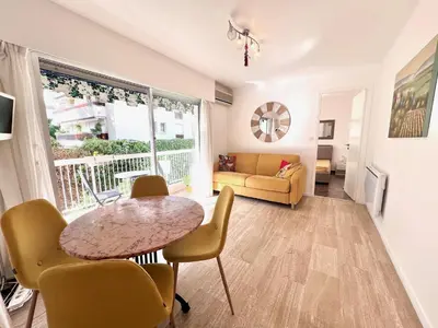a living room with a table and chairs and a couch at Positive in Cannes