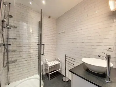 a white bathroom with a sink and a shower at 1-bedroom beachfront apartment with sea view in Cannes