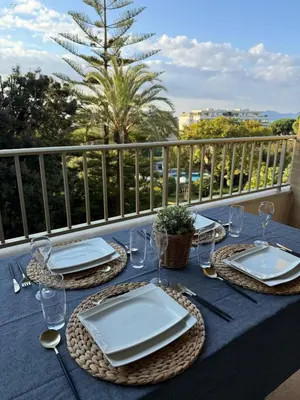 a blue table with plates and glasses on a balcony at Chic 2 bedroom with Huge Terrace and Pool Cannes in Cannes