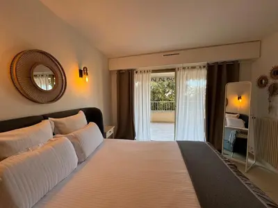 a bedroom with a large white bed and a window at Chic 2 bedroom with Huge Terrace and Pool Cannes in Cannes