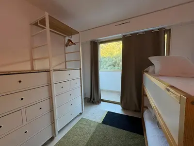 a small bedroom with a bed and a window at Chic 2 bedroom with Huge Terrace and Pool Cannes in Cannes