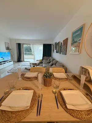 a wooden table with plates and napkins on top of it at Chic 2 bedroom with Huge Terrace and Pool Cannes in Cannes
